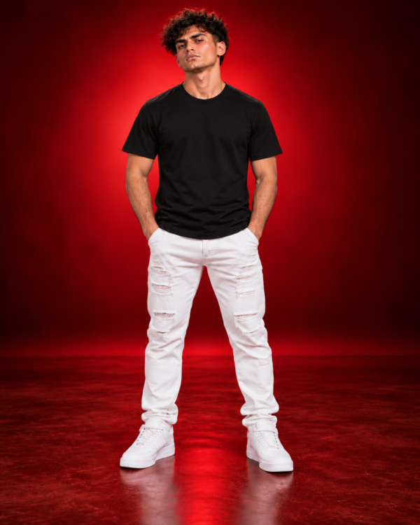 Male model wearing a black BELLA+CANVAS 3001 T-shirt, front view on a red studio background