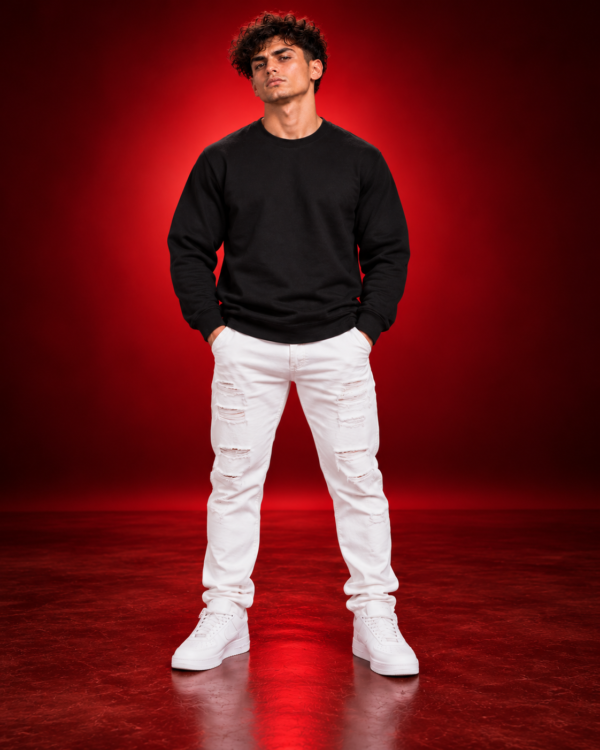 Male model wearing a black Gildan 18000 crewneck sweatshirt, front view on a red studio background