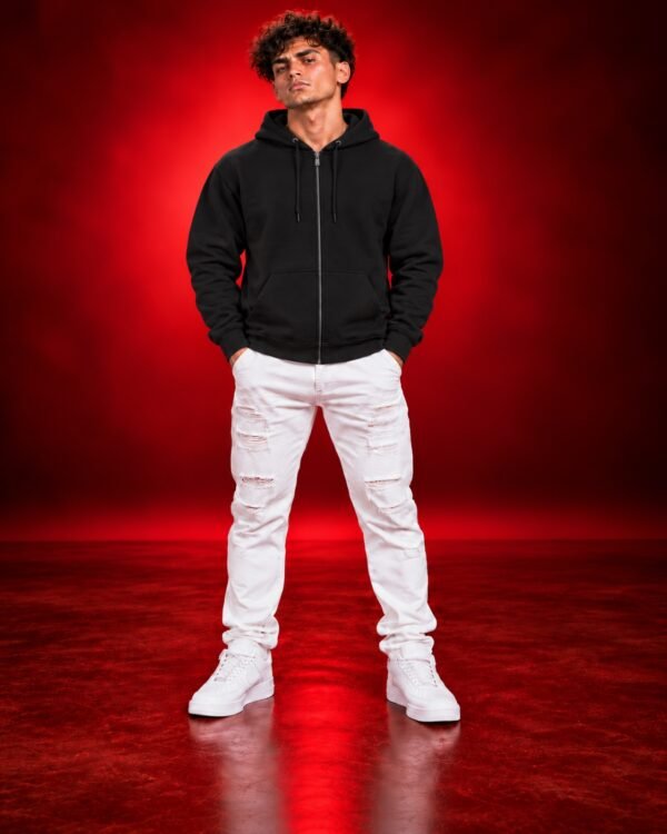 Male model wearing a black Gildan 18600 full-zip hoodie, front view on a red studio background